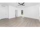 An airy bedroom features hardwood-style floors, a ceiling fan, and a view through a window at 24294 Santa Inez Rd, Punta Gorda, FL 33955