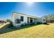 Back of home with large yard, lush landscaping, windows and sliding doors to the covered patio at 24294 Santa Inez Rd, Punta Gorda, FL 33955