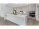 Modern kitchen features an island, quartz countertops, and stainless steel appliances and backsplash at 24294 Santa Inez Rd, Punta Gorda, FL 33955