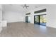 Spacious living room with wood-look tile floors, recessed lighting, ceiling fan, and sliding glass doors at 24294 Santa Inez Rd, Punta Gorda, FL 33955