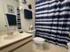 Cozy bathroom with a vanity, a toilet, and a shower with a blue and white striped curtain at 25068 Harborview Rd # 3D, Punta Gorda, FL 33980