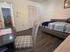 Comfortable bedroom with dark wood floors, a day bed, chair, desk, and a view into other rooms at 25068 Harborview Rd # 3D, Punta Gorda, FL 33980