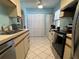 Functional kitchen featuring white cabinets, white tile floors, and black appliances at 25068 Harborview Rd # 3D, Punta Gorda, FL 33980