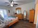 Cozy bedroom featuring a ceiling fan, wood floors, and dresser at 25068 Harborview Rd # 3D, Punta Gorda, FL 33980