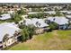 Birds eye view of a condo building featuring a grey roof, lush landscaping, and neighboring houses at 25559 Heritage Lake Blvd # 25, Punta Gorda, FL 33983