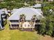 Aerial view of the back of a condo featuring a screened in lanai, palm trees, and lush landscaping at 25559 Heritage Lake Blvd # 25, Punta Gorda, FL 33983