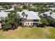 An aerial view of the rear of a yellow condo building with two stories, mature trees, and a lawn at 25559 Heritage Lake Blvd # 25, Punta Gorda, FL 33983