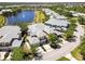An aerial view shows townhomes near a lake with a fountain surrounded by greenery at 25559 Heritage Lake Blvd # 25, Punta Gorda, FL 33983
