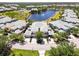 Aerial view of townhomes with a water feature, swimming pool, and lush landscaping at 25559 Heritage Lake Blvd # 25, Punta Gorda, FL 33983