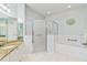 Well-lit bathroom featuring a shower with glass doors and a soaking tub with tile surround at 25559 Heritage Lake Blvd # 25, Punta Gorda, FL 33983