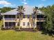 The exterior elevation showcases a screened-in porch, complemented by palm trees and lush green lawn at 25559 Heritage Lake Blvd # 25, Punta Gorda, FL 33983
