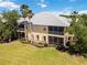 Exterior view showcasing the yellow condo with a screened lanai, palm trees, and lush green landscaping at 25559 Heritage Lake Blvd # 25, Punta Gorda, FL 33983