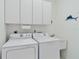 Functional laundry room featuring a washer, dryer, and ample cabinet space at 25559 Heritage Lake Blvd # 25, Punta Gorda, FL 33983