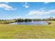 Scenic view of the serene community pond featuring a fountain and lush green landscaping at 25559 Heritage Lake Blvd # 25, Punta Gorda, FL 33983