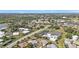 Aerial view of a neighborhood featuring a community pool and tennis courts amid lush greenery at 3106 Heron Shores Dr, Venice, FL 34293