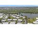 Aerial view captures a community homes beside a picturesque lake and lush forest backdrop at 3106 Heron Shores Dr, Venice, FL 34293