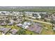 Lush aerial showcases community pool and tennis courts near a tranquil lake and residential homes at 3106 Heron Shores Dr, Venice, FL 34293