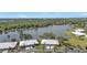 An aerial view of community homes next to a tranquil lake surrounded by green trees at 3106 Heron Shores Dr, Venice, FL 34293