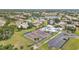 Breathtaking aerial view showcases the community's tennis and sport court near a parking area with lake view homes at 3106 Heron Shores Dr, Venice, FL 34293