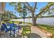 Backyard patio with outdoor seating around a serene lake with mature trees and landscaping at 3106 Heron Shores Dr, Venice, FL 34293