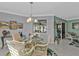 Dining room with comfortable chairs, glass table, pendant lighting, and view to patio at 3106 Heron Shores Dr, Venice, FL 34293