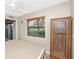 Bedroom with a view of the back yard, neutral walls, a ceiling fan, and wooden accent cabinet at 3123 David St, Punta Gorda, FL 33982