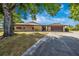 Spacious, tan home with a two-car garage, long driveway, and mature trees in a landscaped yard at 3123 David St, Punta Gorda, FL 33982