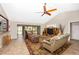 A welcoming living room featuring cozy seating, a ceiling fan, and access to the dining area at 3123 David St, Punta Gorda, FL 33982