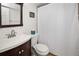 Bathroom features a shower with white curtain, toilet, and vanity sink with storage cabinet at 3310 Loveland Blvd # 1102, Punta Gorda, FL 33980
