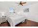 Bright bedroom features a ceiling fan, wood-look flooring, and a window with a view of the outside at 3310 Loveland Blvd # 1102, Punta Gorda, FL 33980