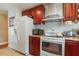 Functional kitchen with white appliances, ample cabinet space, and tile flooring at 402 Cicero Nw St, Port Charlotte, FL 33948