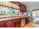 Well-maintained kitchen with wooden cabinets, stainless steel appliances, and a view to the backyard at 402 Cicero Nw St, Port Charlotte, FL 33948