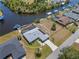 This aerial view showcases a beautiful waterfront property with a screened-in pool, boat dock, and well-maintained landscaping at 4146 Library St, Port Charlotte, FL 33948