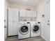 Bright laundry room with white washer and dryer, overhead cabinets, and ample storage space at 4146 Library St, Port Charlotte, FL 33948