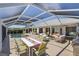 Inviting screened-in patio featuring a pool, dining area, lounge chairs and outdoor kitchen at 4146 Library St, Port Charlotte, FL 33948