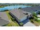 Aerial view of single Gathering home with white garage door and manicured lawn in a lakeside community at 43839 Seedling Ter, Punta Gorda, FL 33982