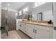 Elegant bathroom with a double sink vanity, granite countertop, and a glass-enclosed shower at 43839 Seedling Ter, Punta Gorda, FL 33982