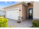 Attached two-car garage leads to a welcoming front entry with a brick paver driveway and sidewalk at 43839 Seedling Ter, Punta Gorda, FL 33982