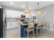 Kitchen with blue island and breakfast bar illuminated by pendant lighting and stainless appliances at 43839 Seedling Ter, Punta Gorda, FL 33982