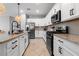 Modern kitchen featuring stainless steel appliances, granite countertops, and herringbone tile backsplash at 43839 Seedling Ter, Punta Gorda, FL 33982