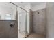 Modern bathroom featuring a glass-enclosed shower with gray tiled walls and updated fixtures at 43839 Seedling Ter, Punta Gorda, FL 33982