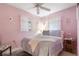 Cozy bedroom with pink walls, two windows, and a comfortable bed with decorative pillows at 5179 Grobe St, North Port, FL 34287