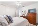 Bedroom with natural light, bed with blue pillows, dresser, and a large flatscreen television at 5179 Grobe St, North Port, FL 34287