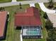 Overhead view of a home with a pool, a brown roof, and green grass all around at 612 Macedonia Dr, Punta Gorda, FL 33950