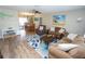 Cozy living room featuring hardwood floors, comfortable seating, and an open view to the dining area at 612 Macedonia Dr, Punta Gorda, FL 33950