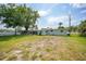 A spacious backyard with a big tree, lawn, and an attached screened in porch at 654 Aqui Esta Dr, Punta Gorda, FL 33950