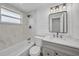 White remodeled bathroom with vanity, toilet, and tub with shower and marble-look tile at 654 Aqui Esta Dr, Punta Gorda, FL 33950