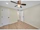 Bright bedroom featuring a ceiling fan, wood-look flooring, and a hallway leading to other rooms at 654 Aqui Esta Dr, Punta Gorda, FL 33950