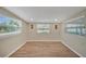 An empty bedroom is brightly lit by three windows and has new wood look tile floors at 654 Aqui Esta Dr, Punta Gorda, FL 33950