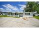An exterior view of the house showing the front yard, long driveway, and curb appeal at 654 Aqui Esta Dr, Punta Gorda, FL 33950